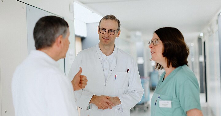Drei Ärztinnen und Ärzte im fachlichen Austausch auf einer Station der Endokrinologie